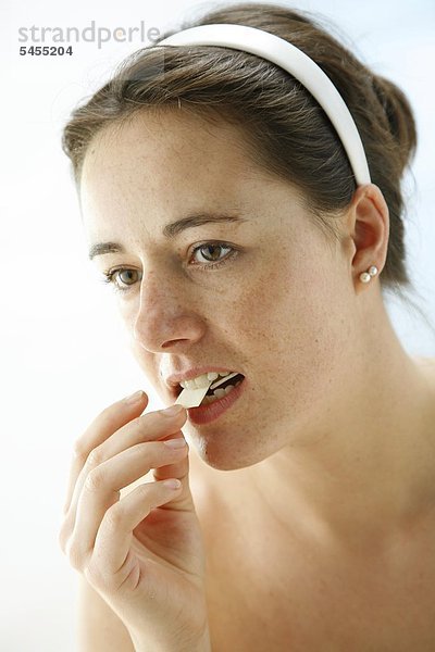 Frau nimmt einen Zahnpflege-Kaugummi