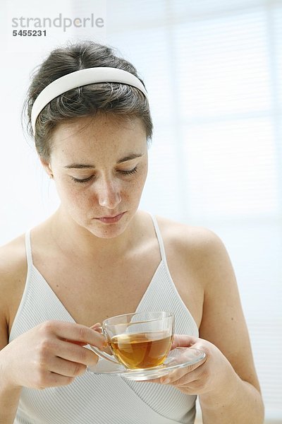 Ernste Frau mit einem Glas Tee