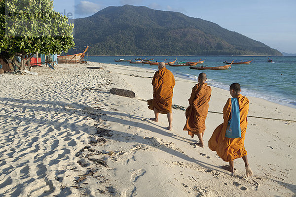 Mönche sammeln Morgenalmosen am Strand  Insel Ko Lipe  Thailand  Asien