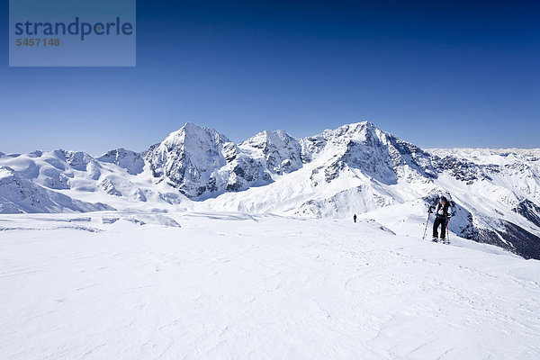 Skitourengeher beim Aufstieg zur hinteren Schöntaufspitze  hinten die Königsspitze  der Ortler und Zebru  Sulden im Winter  Südtirol  Italien  Europa