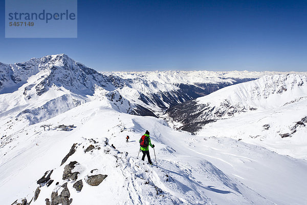 Skitourengeher beim Abstieg der hinteren Schöntaufspitze  hinten der Ortler und das Suldental  Sulden im Winter  Südtirol  Italien  Europa