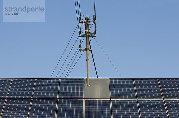 Dach mit Solarmodulen und Strommast  Eigenenergieproduktion  Energiewende  ÖffentlicherGrund