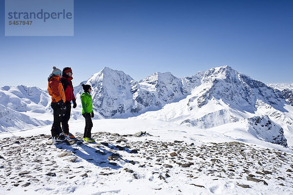 Skitourengeher auf dem Gipfel der hinteren Schöntaufspitze  Sulden im Winter  hinten die Königsspitze  der Ortler und Zebru  Südtirol  Italien  Europa