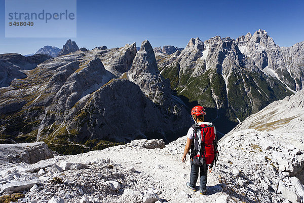 Wanderer im Alpinisteig am Einser  hinten die Dreischusterspitze  unten das Fischleintal  Hochpustertal  Sexten  Dolomiten  Südtirol  Italien  Europa