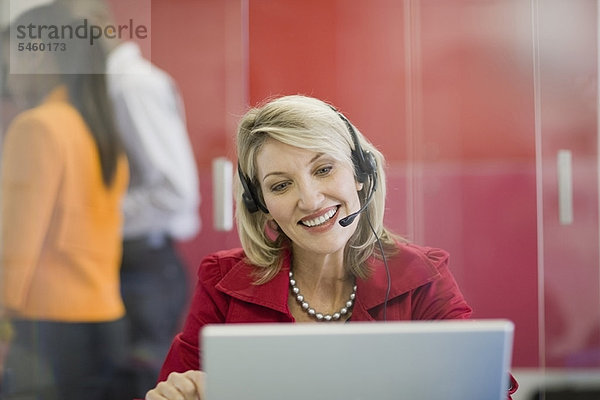 Geschäftsfrau am Headset mit Laptop