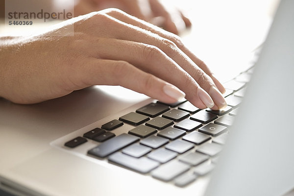 Nahaufnahme der Frau beim Tippen auf dem Laptop