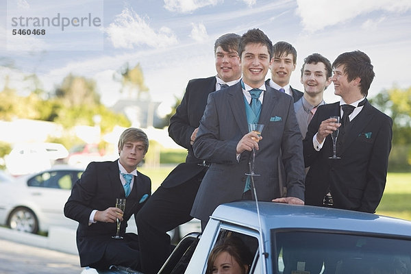 Teenager Jungen in Anzügen lächeln aus dem Auto