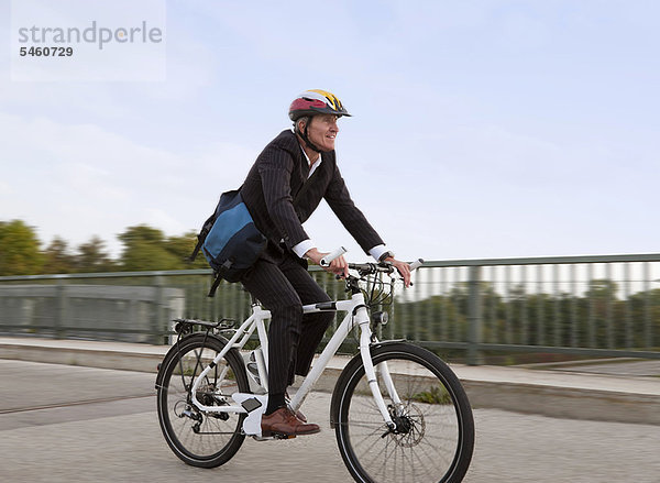 Geschäftsmann mit Fahrrad auf der Brücke