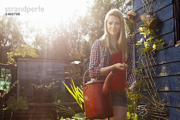 Frau mit Gießkanne im Garten