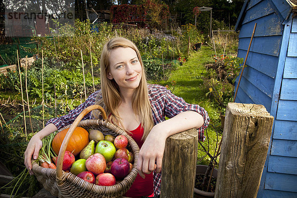 Frau sammelt Gemüse im Garten