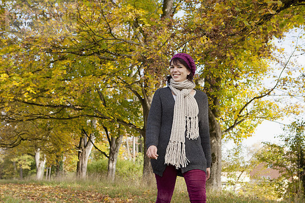 Lächelnde Frau beim Spaziergang im Park