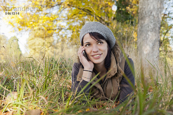 Frau spricht am Handy im Park