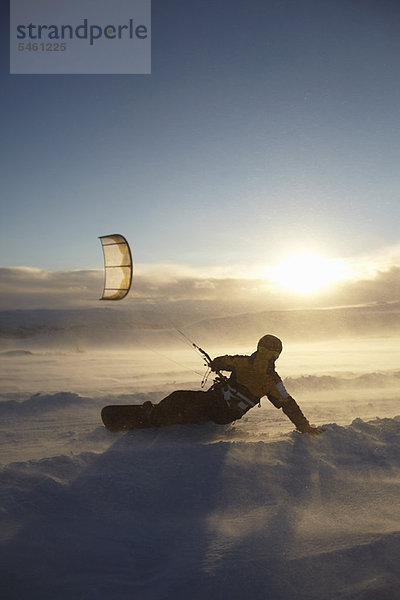 Mann Windsurfen auf dem Snowboard
