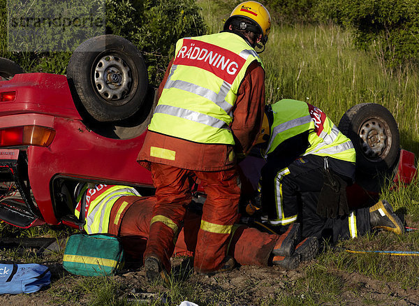 Feuerwehrleute retten Menschen aus abgestürzt Auto