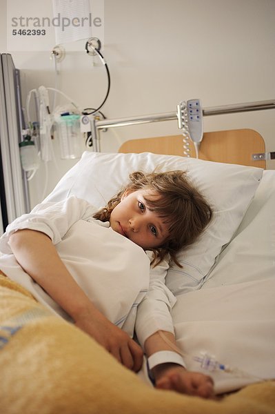 Girl lying on Krankenhausbett mit Tropf auf arm