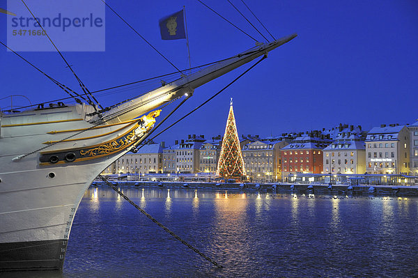 Boot mit beleuchteten Weihnachtsbaum und Gebäude im Hintergrund