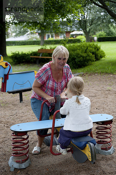Mädchen und Großmutter spielen Spielplatz