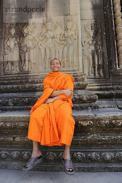 Buddhistischer Mönche im Zentrum von Angkor Wat vor einem Relief auf dem Apsara aus der hinduistischen Mythologie dargestellt sind  Kambodscha  Südostasien  Asien