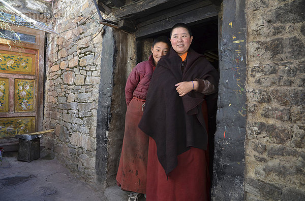 Zwei tibetische Nonnen stehen vor der Klosterküche des Nonnenklosters in den Bergen von Kloster Reting  Mount Gangi Rarwa  Himalaya  Lhundrup County  Zentraltibet  Tibet  China
