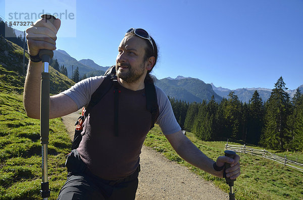Junger Mann  Wanderer mit Trekkingstöcken unterwegs auf den Wanderwegen im Berchtesgadener Land  Gotzenalm  Schönau  Königsee  Bayern  Deutschland  Europa