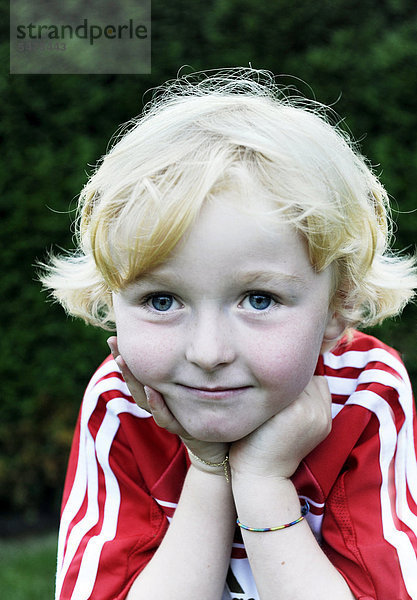 Fünfjähriger Junge in FC Bayern München Dress stützt sich auf den Händen auf  Portrait