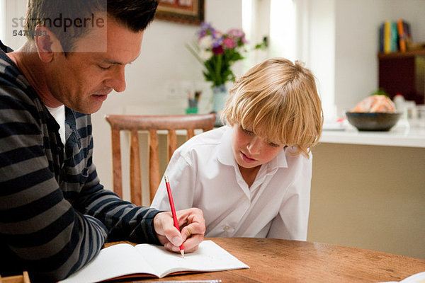 Vater hilft dem Sohn bei seinen Hausaufgaben