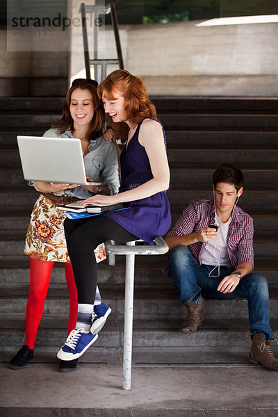 Zwei young Woman looking at Laptop unten Schritte