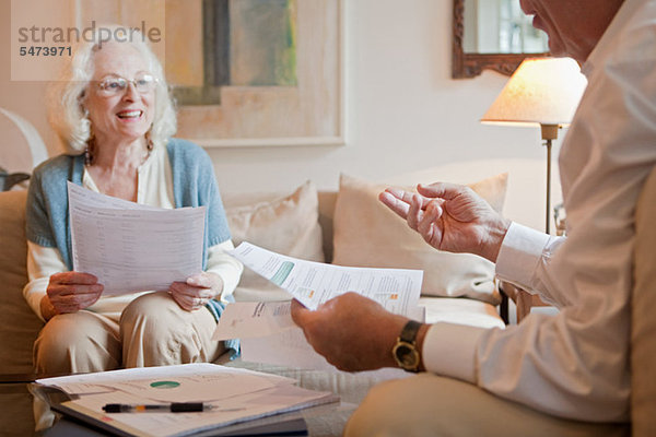 Seniorenpaar diskutiert zu Hause über den Papierkram