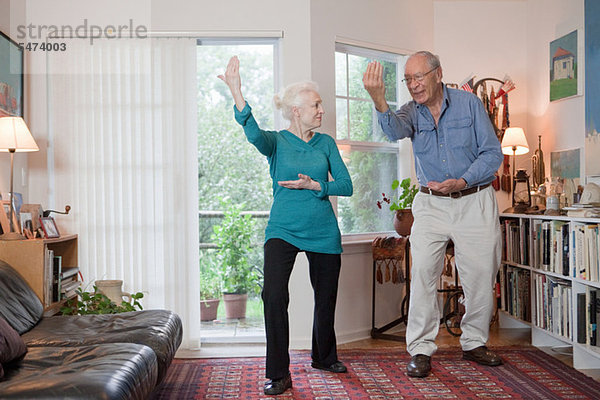 Seniorenpaar beim Tai Chi im Wohnzimmer