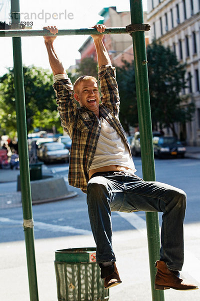 Mitte Erwachsene Mann hängen von street Lamp post
