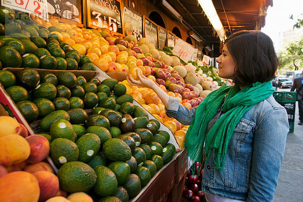 Junge Frau beim Einkaufen am Marktstand