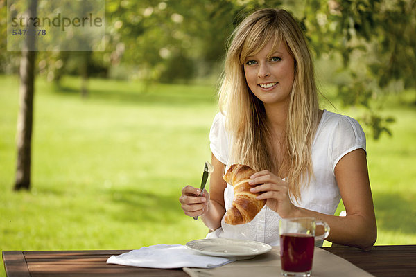 Junge Frau mit Croissant