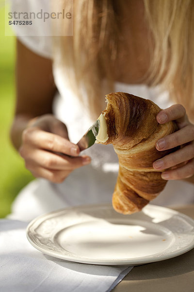 Junge Frau mit Croissant