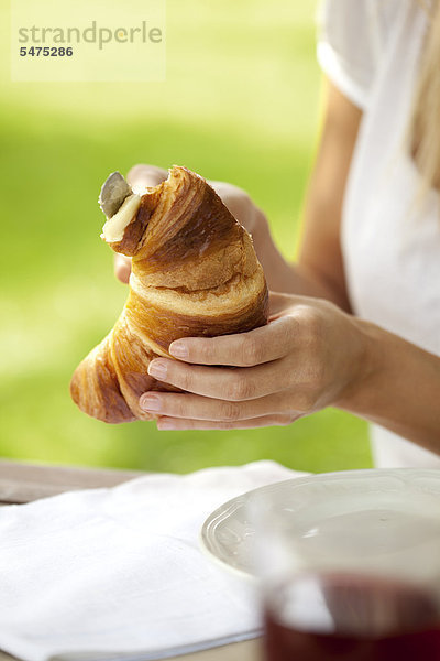 Junge Frau mit Croissant