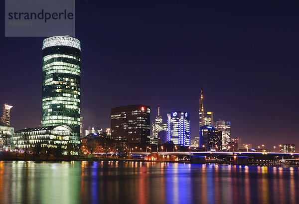 Skyline von Frankfurt mit Westhafen-Turm und Friedensbrueckebrücke vom südwestlichen Ufer des Main  nachts  Frankfurt am Main  Hessen  Deutschland  Europa