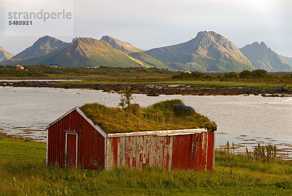 Hütte mit einem Grasdach vor den Gipfeln der Insel Lang¯ya  Inselgruppe VesterÂlen  Nordland  Norwegen  Europa