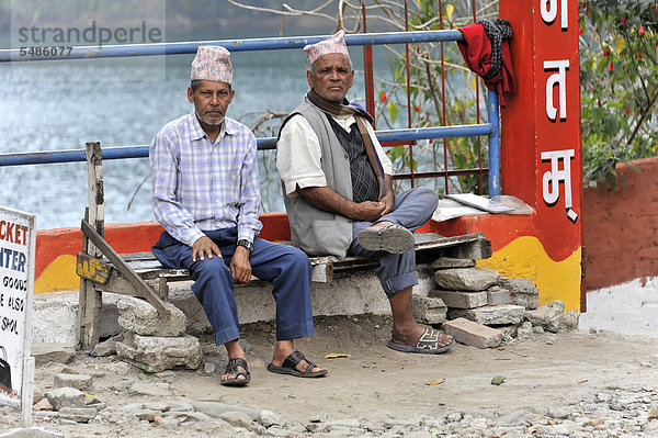 Zwei alte Nepalesen sitzen auf Bank am Phewa-See  Pokhara  Nepal  Asien