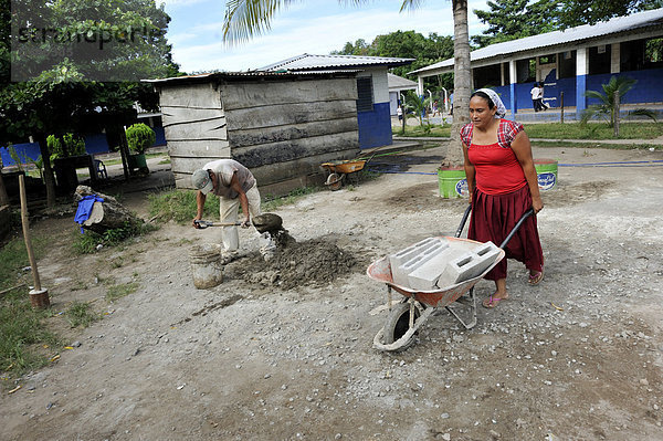 Frau mit einer schweren Schubkarre auf einer Baustelle  Las Mesitas  Jiquilisco  El Salvador  Zentralamerika  Lateinamerika
