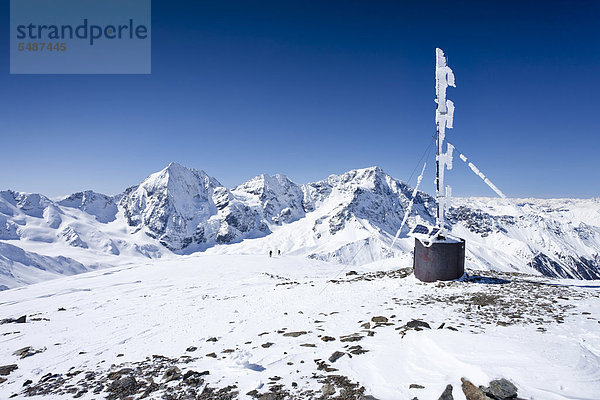 Skitourengeher auf dem Gipfel der hinteren Schöntaufspitze mit der Wetterstation  Sulden im Winter  hinten die Königsspitze  der Ortler und Zebru  Südtirol  Italien  Europa