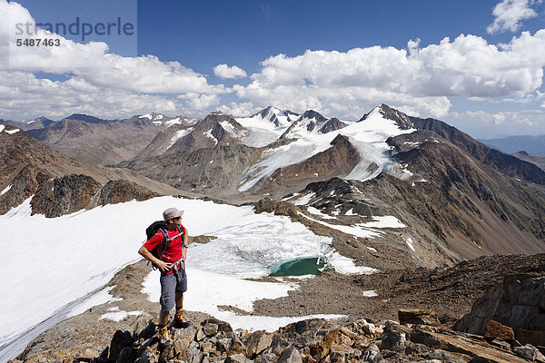 Wanderer beim Aufstieg zur Finailspitz im Schnalstal durch das Tisental  hinten der Similaun und die hintere Schwärze  unten das Tisenjoch und das Hauslabjoch mit der Fundstelle von Ötzi  Südtirol  Italien  Europa