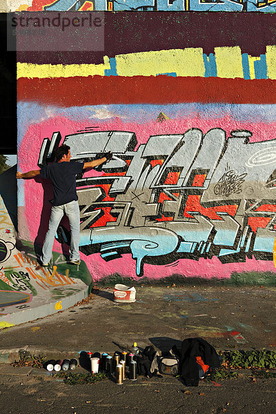 Graffiti-Künstler bei der Arbeit an einer Betonwand unter der Ernst-Walz-Brücke  Heidelberg  Baden-Württemberg  Deutschland  Europa