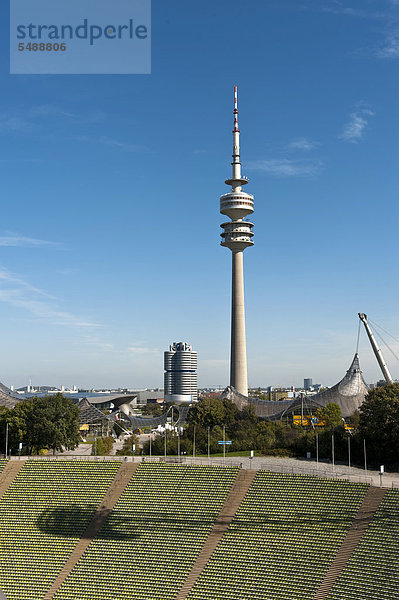 Blick über die Sitzplätze des Münchner Olympiastadions Richtung Fernsehturm  BMW Vierzylinder  links davon  und BMW Welt  links  in München  Bayern  Deutschland  Europa