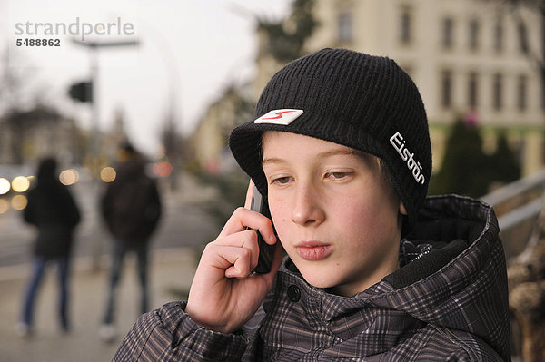 Junge  12  13 Jahre  mit Mobiltelefon