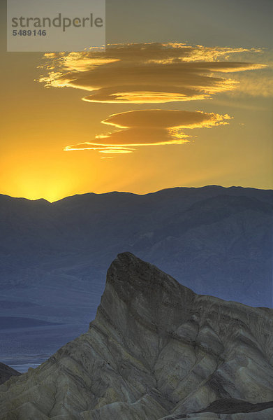 Entstehung einer Sierra Wave Wolkenformation im Abendlicht  Blick von Zabriskie Point  Zabriske Point  auf durch Mineralien verfärbtes erodiertes Gestein des Manly Beacon  dahinter Panamint Range  Sonnenaufgang  Death Valley Nationalpark  Mojave-Wüste  Kalifornien  Vereinigte Staaten von Amerika  USA