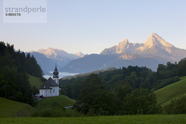 Deutschland  Bayern  Berchtesgaden  Blick auf Kapelle mit Bergen im Hintergrund bei Sonnenaufgang