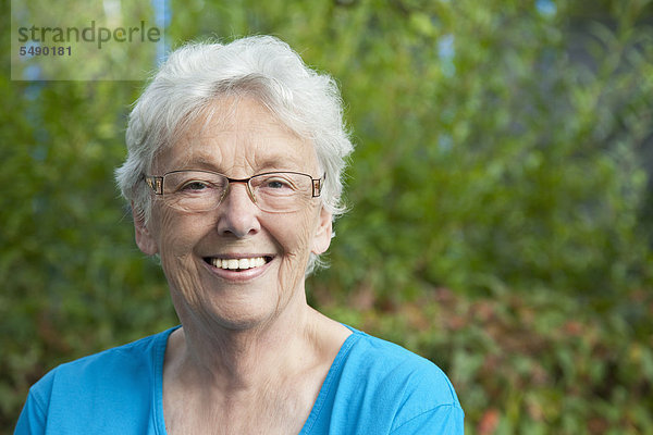 Seniorin im Garten  lächelnd  Portrait