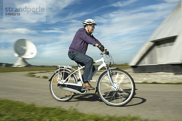 Mann mit Elektrofahrrad in der Nähe des Radiosenders