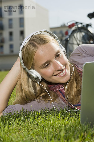 Teenager Mädchen mit Tablet PC und Musik hören  lächeln
