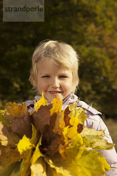 Mädchen hält Blätter  lächelnd  Portrait