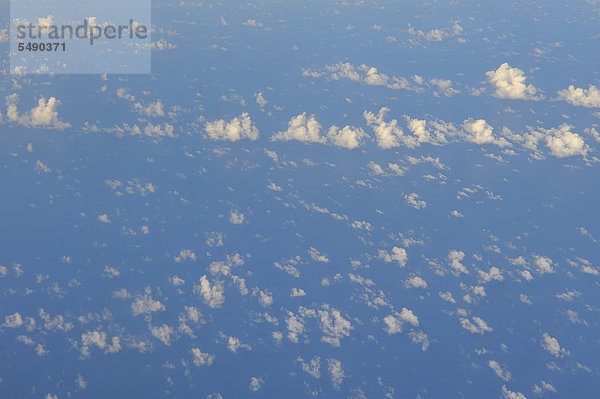 Blick auf Wolken mit karibischem Meer vom Flugzeug aus